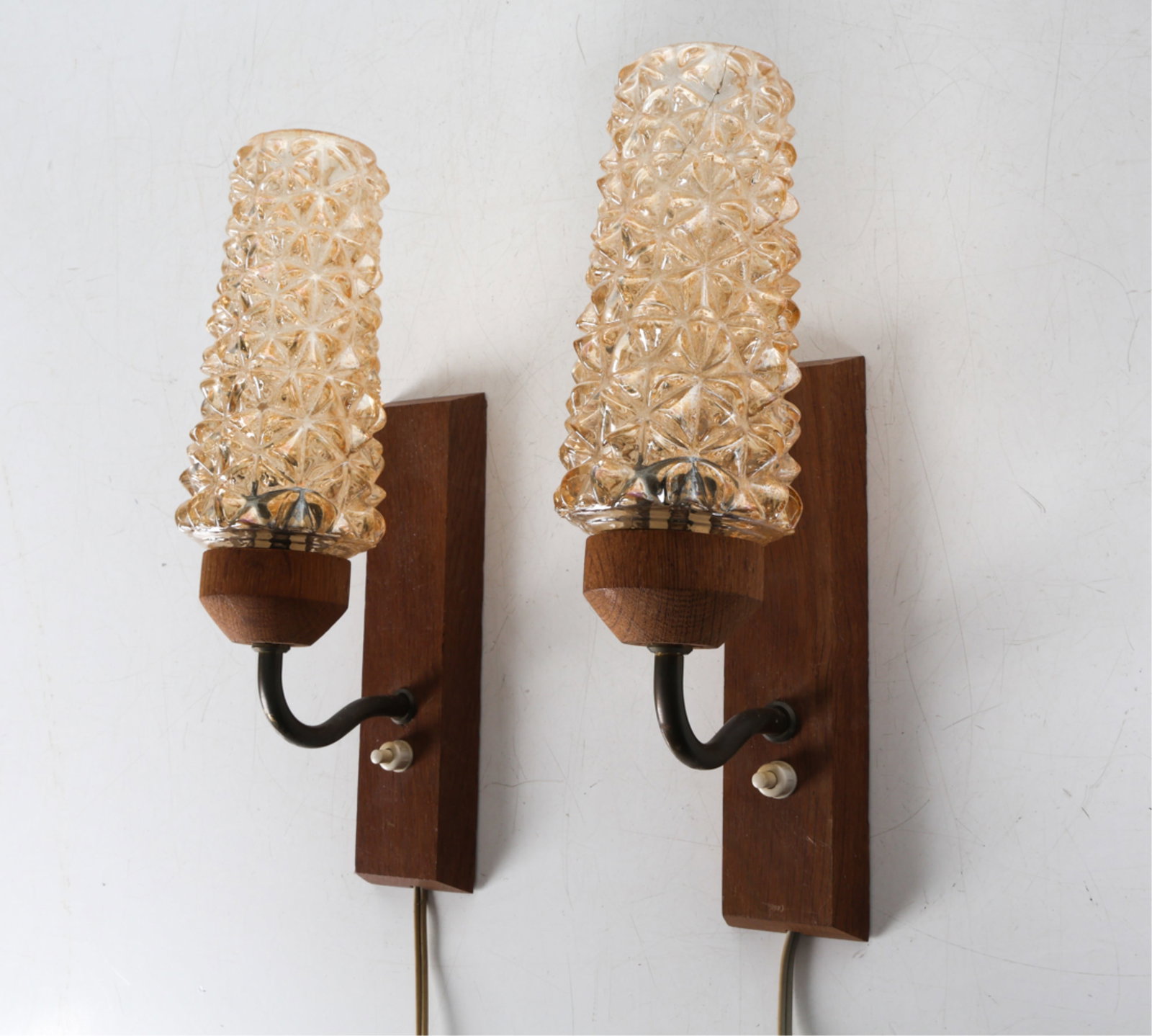 PAIR OF DANISH GLASS AND TEAK WALL SCONCES: Textured amber glass shades. Circa 1960's. Dimensions: H 12" x W 3.5" x D 5.75". Condition: Wiring untested, Few scuffs and scratches to wood. Wear consistent with age and use. DMK048