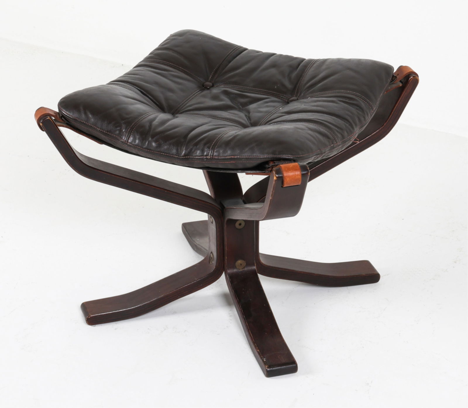 ATTR. SIGURD RESSELL FALCON OTTOMAN C.1970'S: Apparently unsigned. Brown hued leather cushion. Buckle corners and bent wood frame. Dimensions: H 17.5" x W 22" x D 21.5" Condition: Rubbing, marks and scratches to wood. Creases and marks to leather