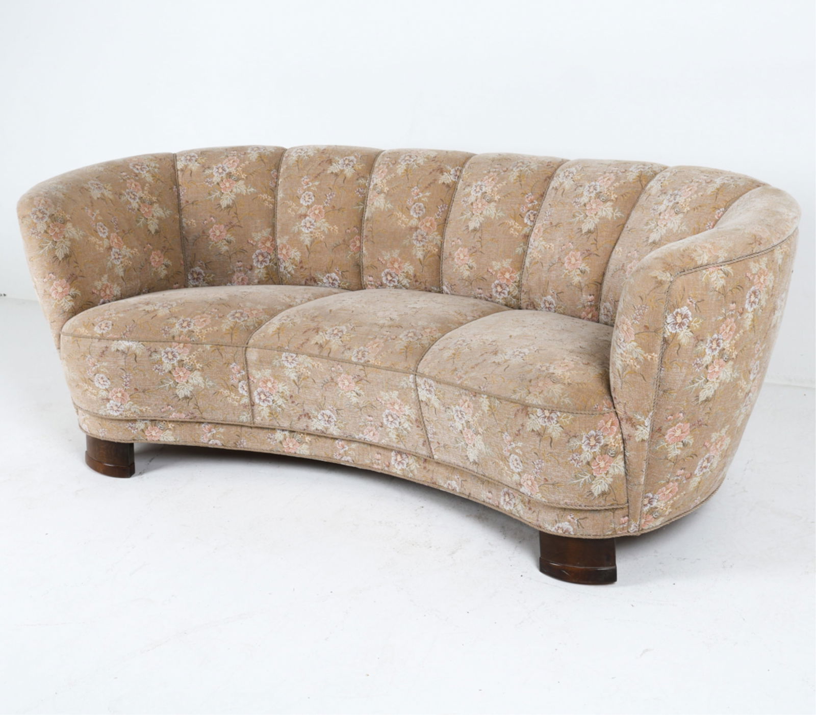 DANISH FLORAL FABRIC BANANA SOFA, C.1950'S: Channel back. Stitched floral design. Oak legs. Dimensions: H 30" x W 69" x D 38" x SH 16.25". Condition: Few rubs to legs. Minor signs of wear to fabric. Wear consistent with age and use. DMK001