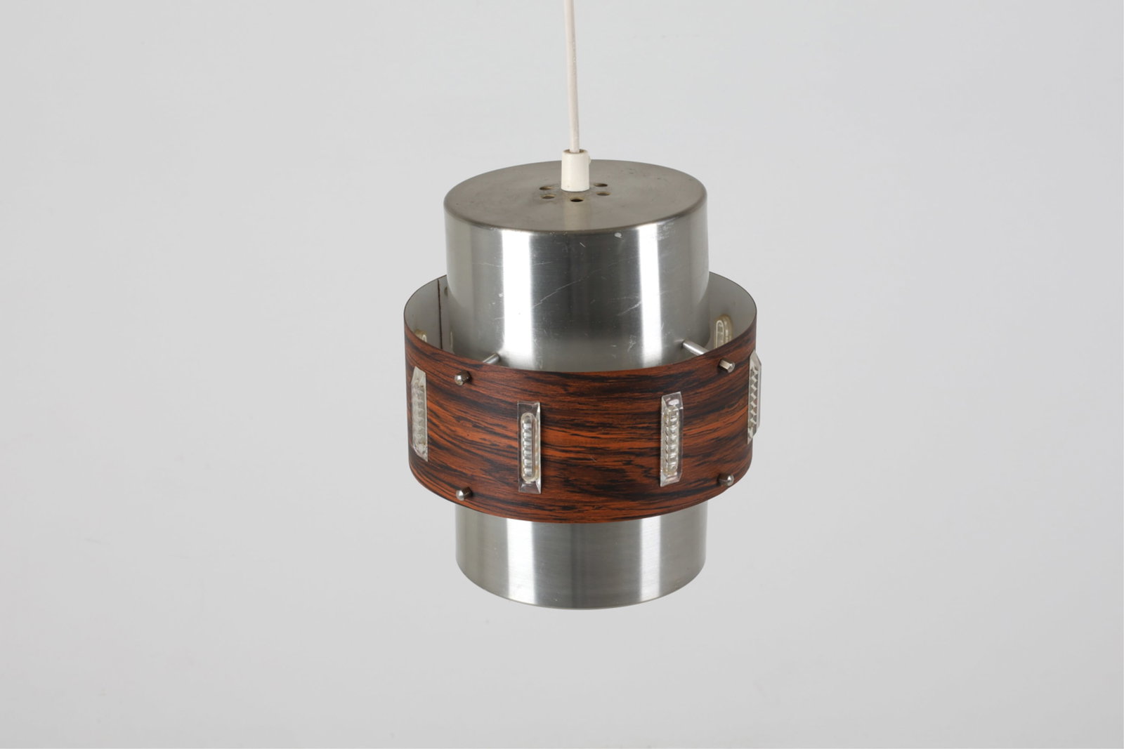 LYSKAER BELYSNING ALUMINUM PENDANT LIGHT, C.1970'S: With metal ring around center that has laminate surface in imitation of rosewood. Denmark, circa 1970's. Dimensions: H 9" x Dia. 8.5". Condition: Wiring untested, requires rewiring. Few scuffs and sur