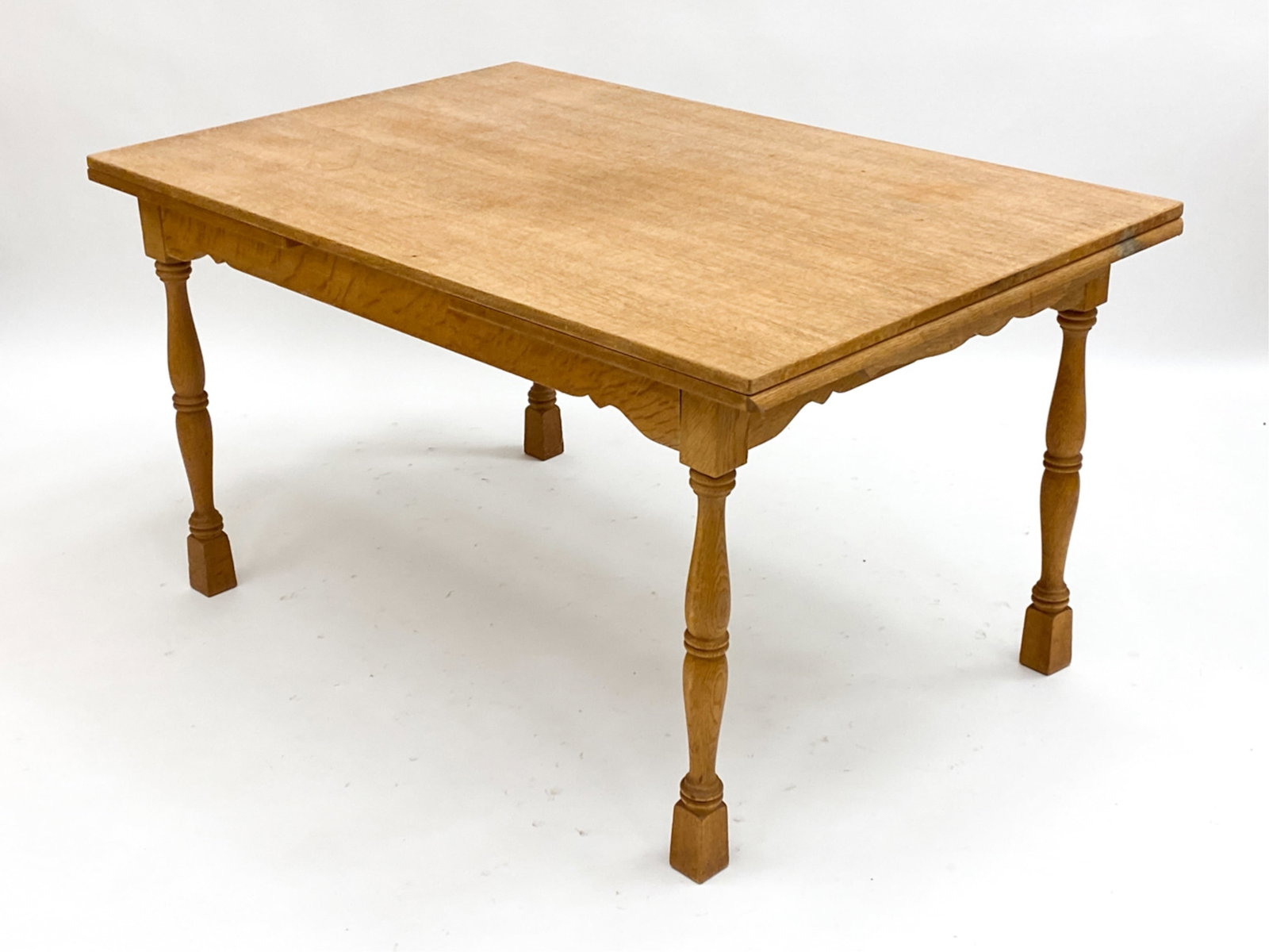 DANISH OAK EXTENSION TABLE IN KJAERNULF STYLE: Hidden leaf dining table. In the manner of Kjaernulf Dimensions: H 29" x W 54.5" x D 35" (Leaf) W 20.5" Condition: Few scattered marks, consistent with age and use, including water stains. F003