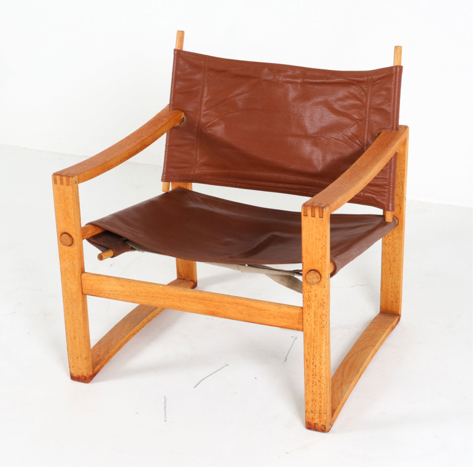 KARIN MOBRING STYLE BEECH & LEATHER SLING CHAIR: Beech Safari style chair with leather sling upholstery. Denmark, Circa 1970's. Dimensions: H 28" x W 25.5" x D 22.75" x SH 14". Condition: Ties for seat nead adjustment. Some wear and drying to leathe
