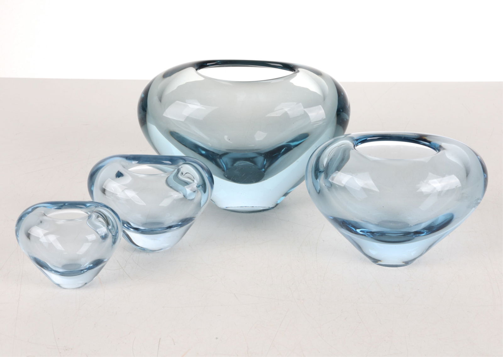 (4) HOLMEGAARD DANISH ART GLASS VASES: Signed to undersides., with edition numbers. Blue tone. Heart forms Dimensions: (Largest) H 5.5" x W 8" x D 4.75" Condition: Marks, scuffs and scratches to undersides and surfaces.