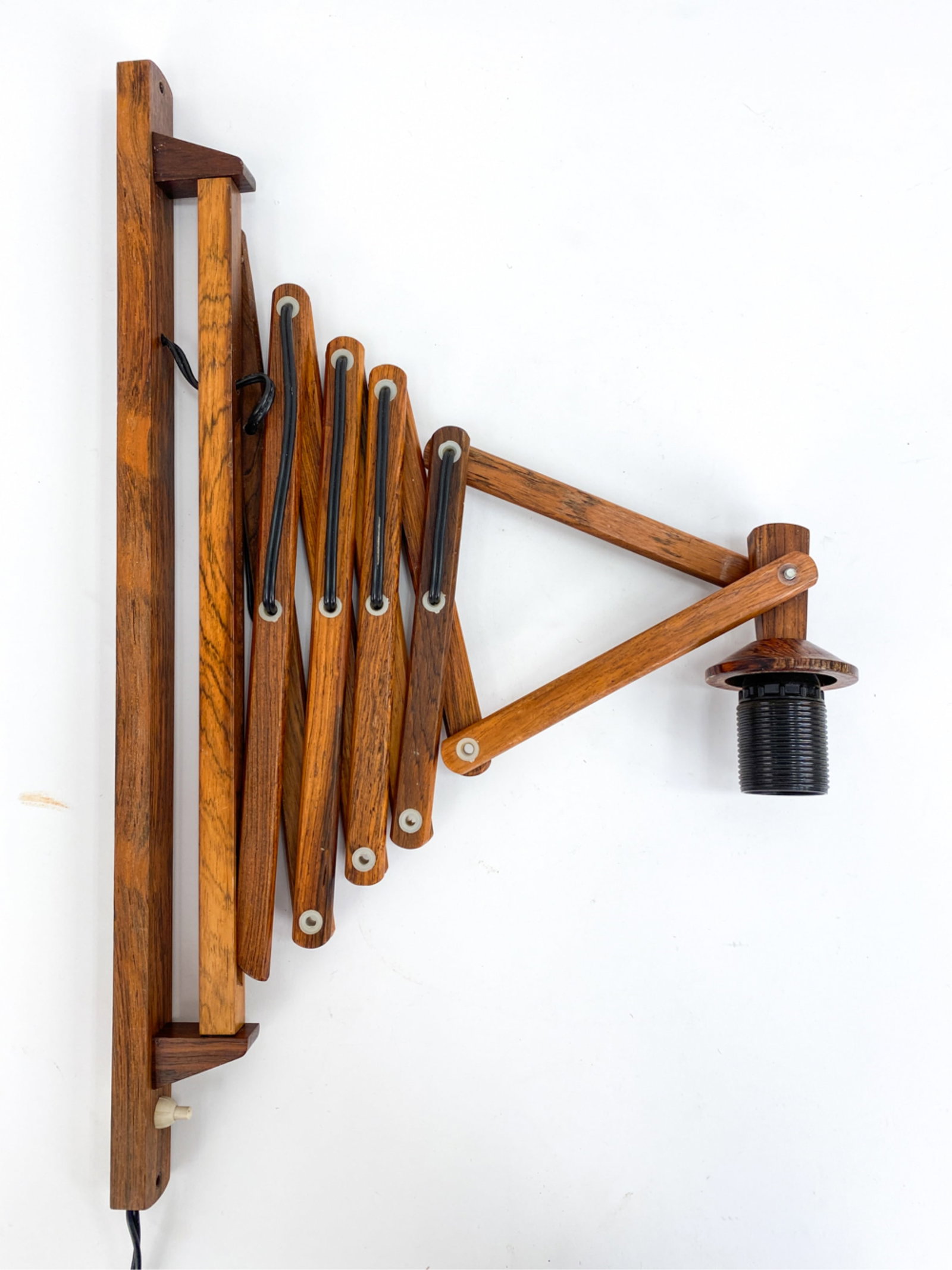 DANISH ROSEWOOD SCISSOR WALL SCONCE C.1960'S: No shade. With push button Dimensions: H 21.5" x W 1.24" x L 21" Condition: Marks and scuffs to interlocked hinges. European plug. Untested. PJ181