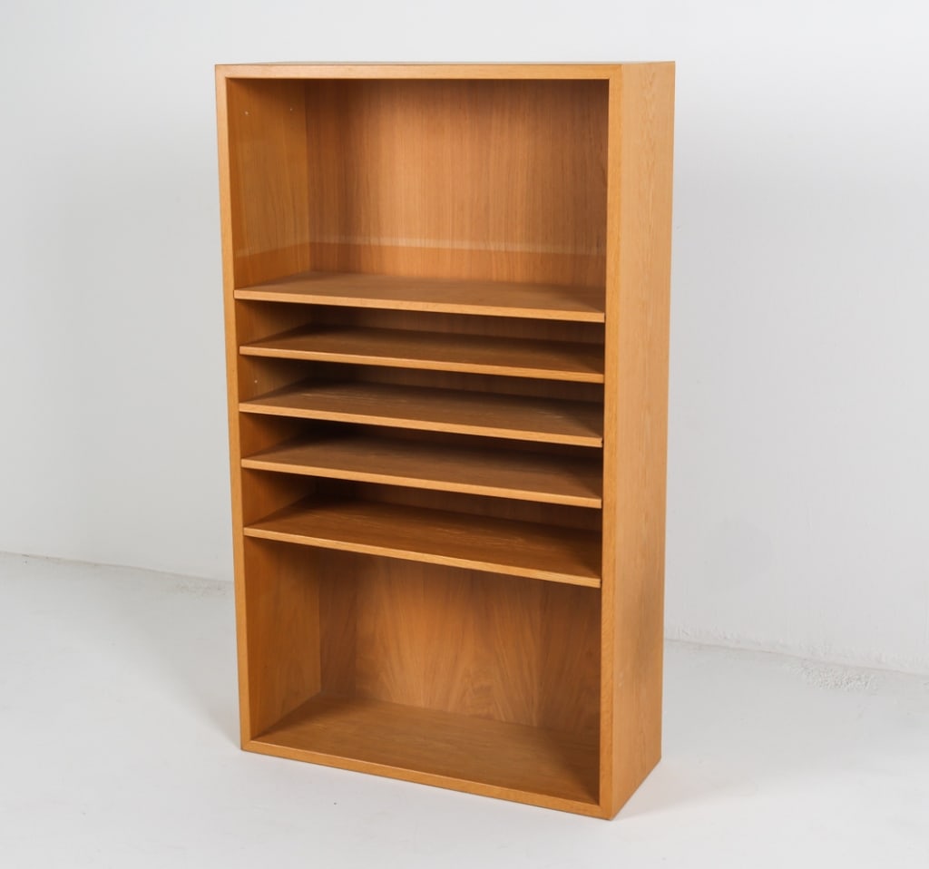 KARL ANDERSSON & SONER OAK BOOKCASE C.1960'S: Label to backside. With adjustable shelves. Dimensions: HG 49.5" x W 27" x D 10.25" Condition: Sun fading to proper right side. Drilled holes to right side. Minor marks and scuffs. Wear consistent wit