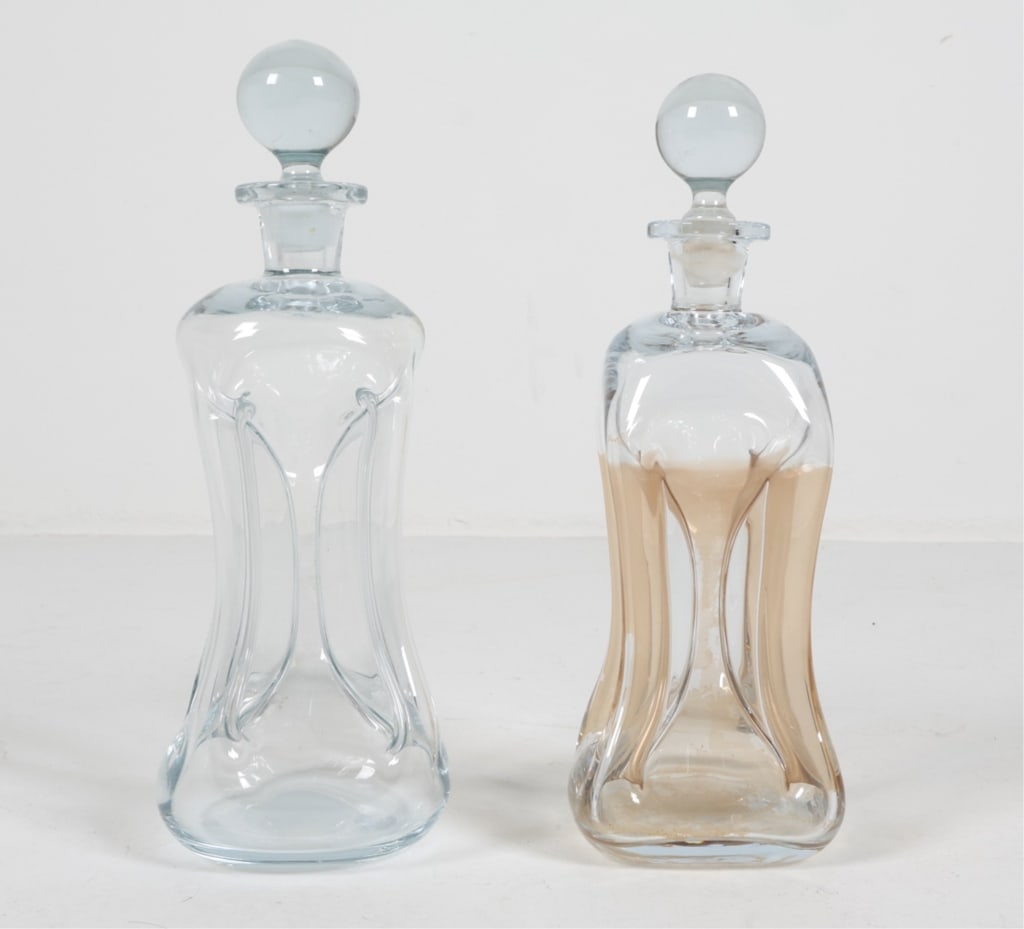 (2) HOLMEGAARD 'KLUK KLUK' DANISH GLASS DECANTERS: Circa 1950's. Dimensions: H 13" x Dia 5". Condition: Sticker residue. staining to interior of one decanter. Presents well overall.