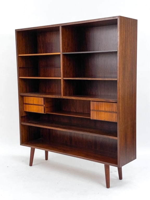 GUNNI OMANN FOR OMANN JUN ROSEWOOD BOOKCASE: Circa 1960's. Designed by Gunni Omann for Omann Jun Mobelfabrik. With a Omann label on back. Dimensions: H 55" x W 47.25" x D 11.5" Condition: Legs may not be original. Holes through back most likely