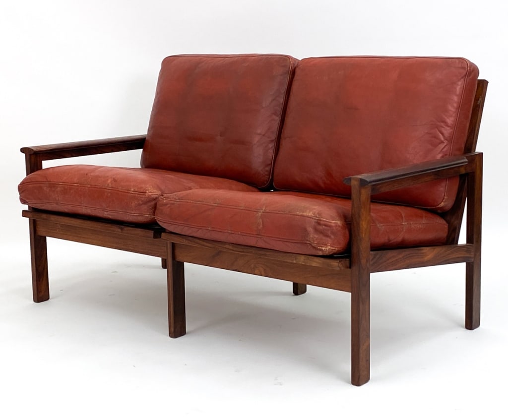ILLUM WIKKELSO FOR NIELS EILERSEN "CAPELLA" SOFA: Danish rosewood and red leather 2-seater sofa designed by Illum Wikkelso for Niels Eilrsen. Model Capella. Circa 1960's. Dimensions: H 30" x W 50.5" x D 28" x SH 16.5" Condition: Some distress to leat