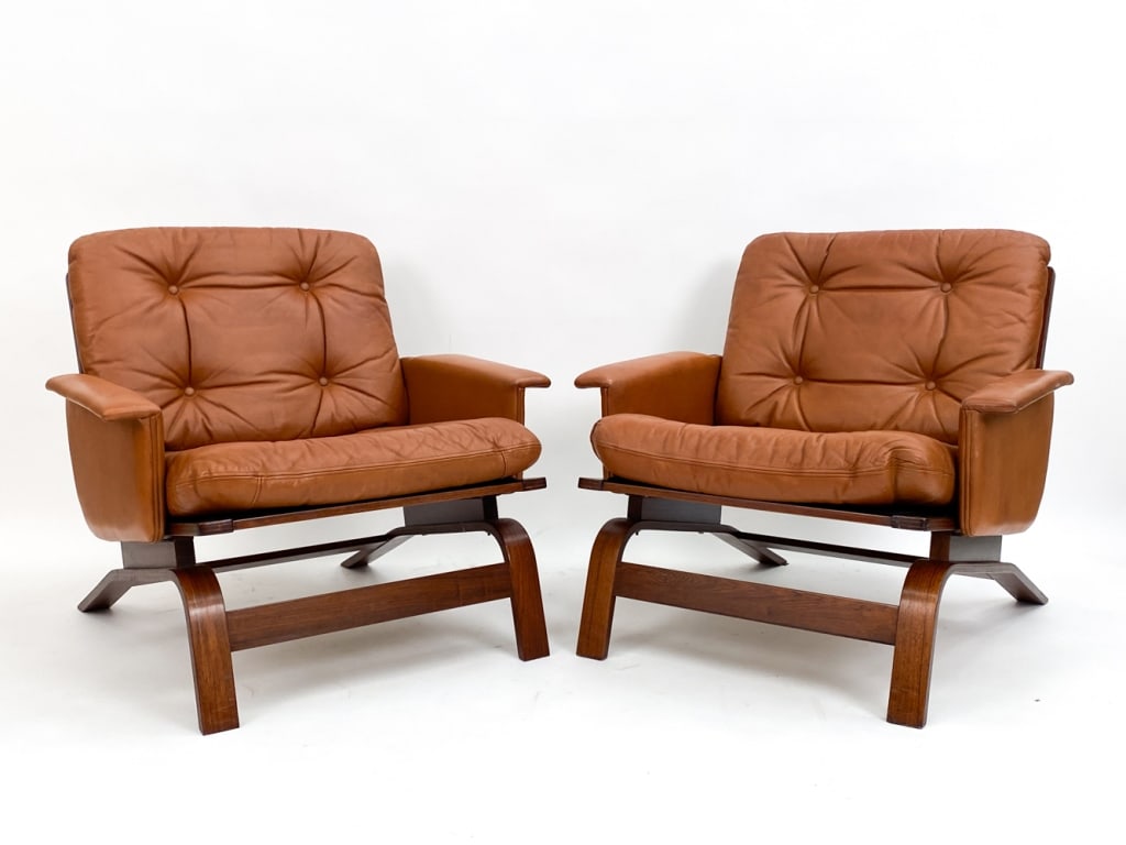 PAIR OF DANISH LEATHER & ROSEWOOD EASY CHAIRS: Pair of chairs with brandy colored leather and rosewood frames. Unmarked. Circa 1960's. Dimensions: H 28.5" x W 30.25" x D 29" x SH 15" Condition: Scuffs and marks to leather and wood, consistent with