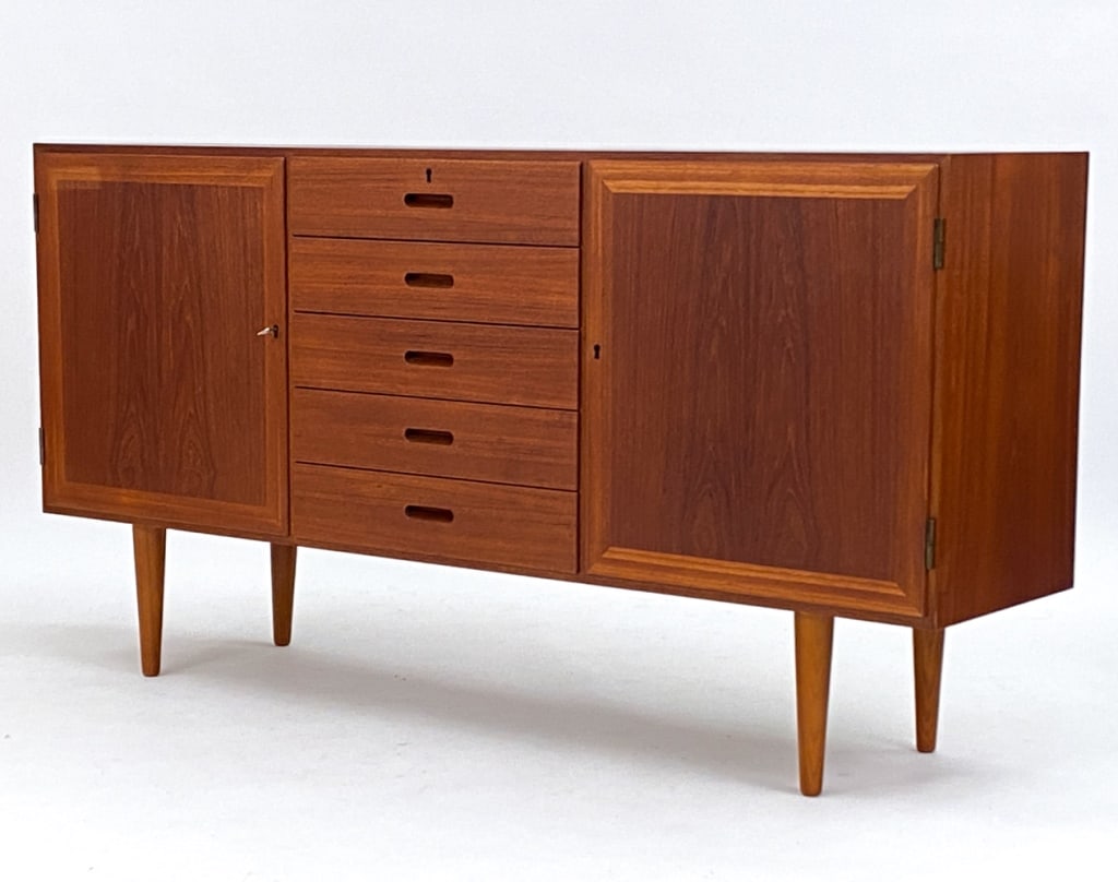 KAI WINDING FOR P. JEPPESENS TEAK SIDEBOARD: Danish teak sideboard with shelves on interior of each side and 5 drawers in middle. Designed by Kai Winding for P. Jeppesens mobelfabrik. Includes a key. Circa 1960's. Dimensions: H 33.25" x W 64" x 