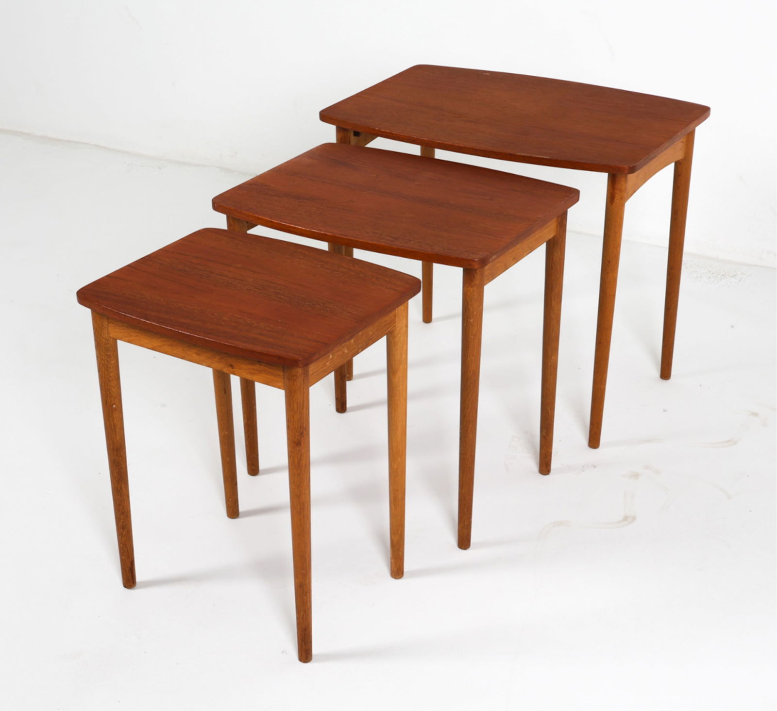 DANISH TEAK NESTING TABLES: Dimensions: H 19" x W 21.25" x D 15" Condition: Scattered scuffs and rubbing on legs. Minor nicks on surface. Wear consistent with age and use. DML066