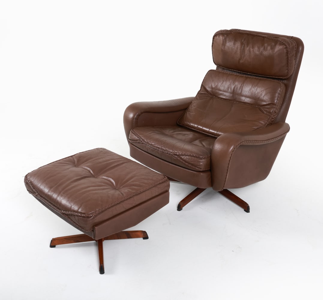 SCHUBELL MADSEN LEATHER LOUNGE CHAIR & OTTOMAN: Rosewood and steel swivel bases. Braided leather trim. Denmark. Dimensions: Chair H 38" x W 32" x D 30" x SH 14.5". Ottoman H 14.75" x W 22.5" x D 20". Condition: Losses to edges of wood on swivel bas