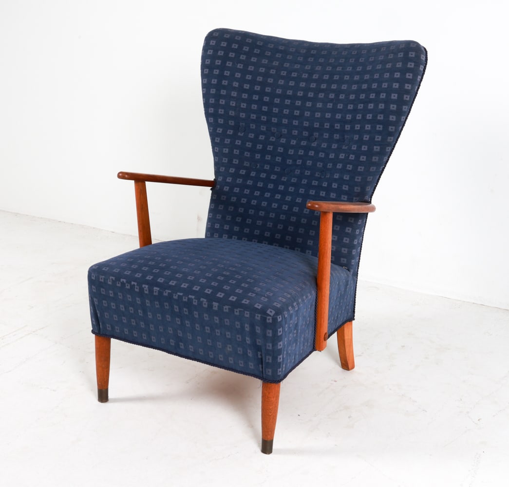 SCHUBELL & MADSEN OAK LOUNGE CHAIR C.1960'S: Designed by Acton Schubell and IB Madsen. Blue patterned fabric upholstery. Denmark, circa 1960's. Dimensions: H 39" x W 25" x D 24" x SH 16". Condition: Trim loose in place. Few scuffs and rubs to wo