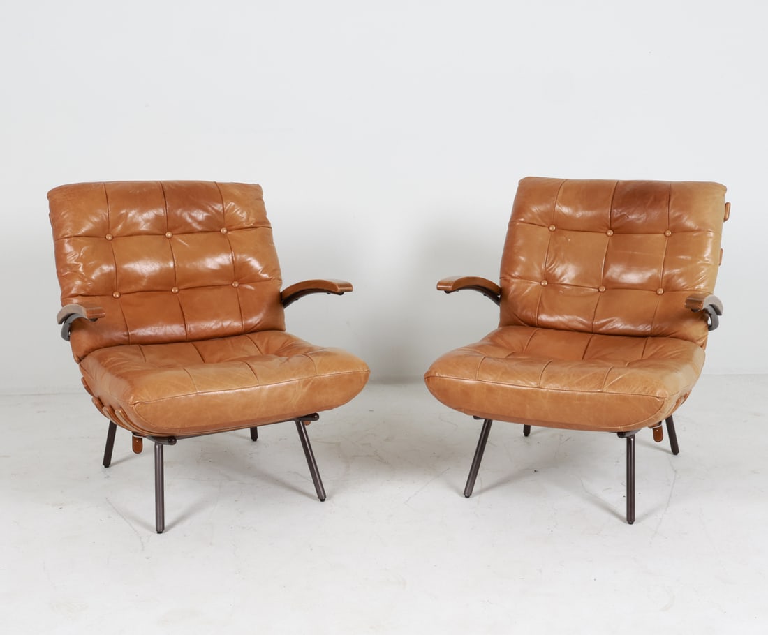 PAIR OF OAK & LEATHER LOUNGE CHAIRS: Oak and steel frame with brandy leather cushions. Denmark. Late 20th C. Dimensions: H 31.5" x W 27.5" x D 31" x SH 16.25". Condition: Some wear to leather, areas of creasing and slight discoloration. 