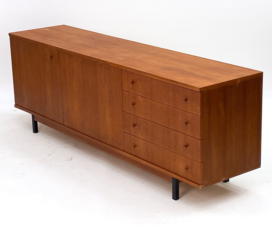 LEO BUB FOR BUB WERT MOBEL TEAK SIDEBAORD C. 1960S: German. Label to interior cabinet door. Black metal post legs. Teak Dimensions: H 25" x W 71"x D 16.5" Condition: Scuffs and marks to finish on lower edges. Scuffs to surface. Wear consistent with age