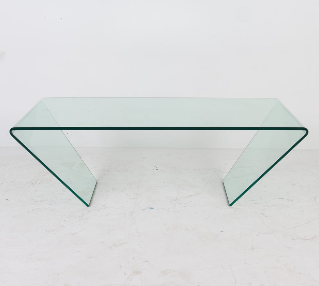 GLASS COFFEE TABLE: With beveled edges. Dimensions: H 15.5"x W 47.25"x D 25.75" Condition: Scattered scuffs and scratches to glass surface. Wear consistent with age and use.