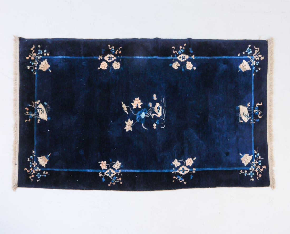 ART DECO CHINESE WOOL RUG: Navy blue tone with fringe. With images of fans and center image of a water fowl. Dimensions: L 82.5" x W 48.25" Condition: Rug appears to have been cut, creating uneven edges. Light fraying on edges.