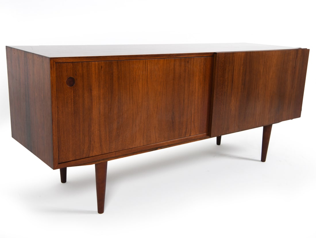 DANISH ROSEWOOD SIDEBOARD C. 1960'S: Adjustable shelves. Dimensions: H 27.5" x W 63.5" x D 19.75". Condition: Notches cut out on back for the option to add supports for a top cabinet which is not included. Few surface scratches. Wear con