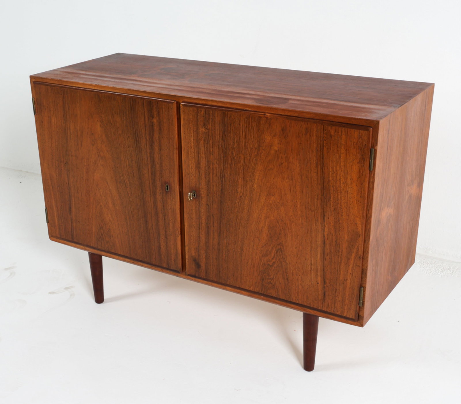 ATTR. HUNDEVAD DANISH ROSEWOOD SIDEBOARD CABINET: Stamp to backside. With Key. Dimensions: H 29.5" x W 42.5" x D 17" Condition: Wear consistent with age and use. Scattered marks to top . sun fading. DMK165
