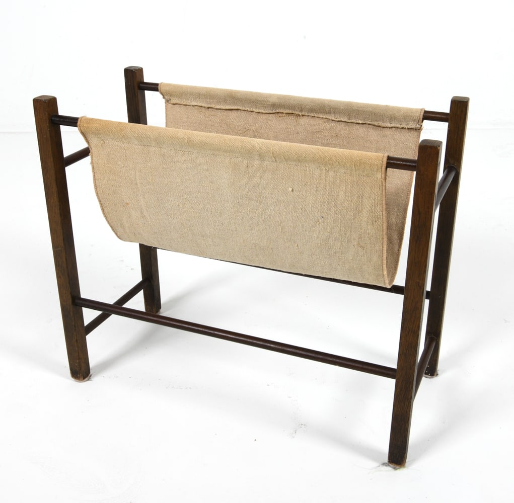 DANISH OAK & CANVAS MAGAZINE RACK C. 1970'S: Canvas sling. Dimensions: H 16" x W 19.5" x D 9". Condition: Some discoloration to canvas. Wear consistent with age and use. DMM145