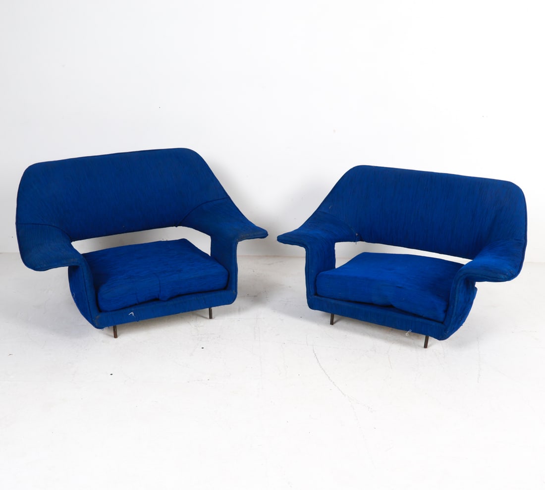 PAIR OF MID-CENTURY SCULPTURAL LOW LOUNGE CHAIRS: Circa 1970's Sculptural forms with iron legs. sits very low to the ground.Dimensions: H 23.5" x W38" x D 22" Seat height 8"Condition: Cleaning-recommended. Rubbing on upholstery. One with tear on inne