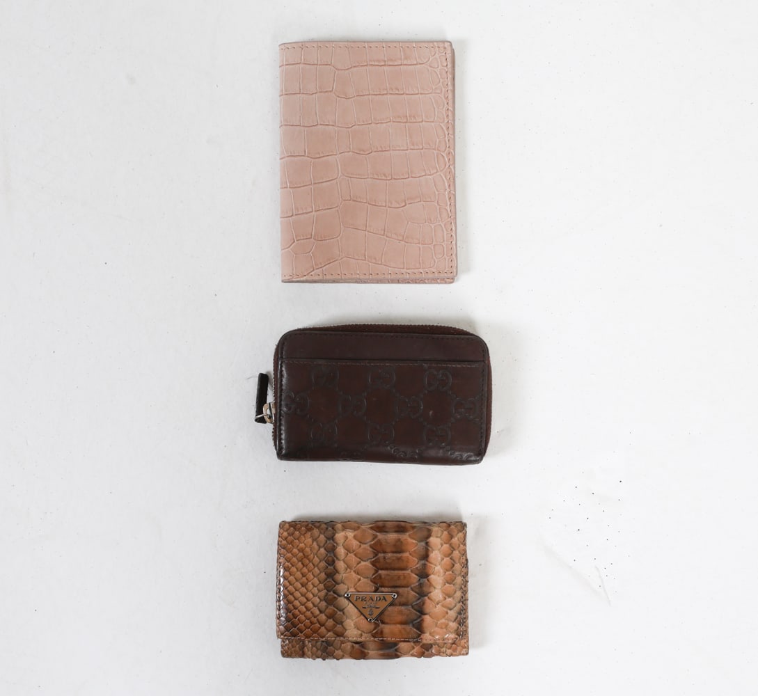 DESIGNER COIN PURSES GUCCI & PRADA: With Gucci monogrammed leather coin purse, marked on interior leather, with serial number 256810 - 496085. Prada snake skin tri-fold wallet with inner tag marked LN 03735 and stamped on inner corners.