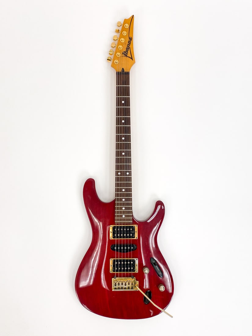 IBANEZ SV-470 6-STRING RED ELECTRIC GUITAR: #F240932, circa early 1990s, made in Japan. With gold-toned hardware, maple viper neck and rosewood fingerboard. Includes Trutone music case and whammy bar.Condition: Lacking backplate. Wear to gold f