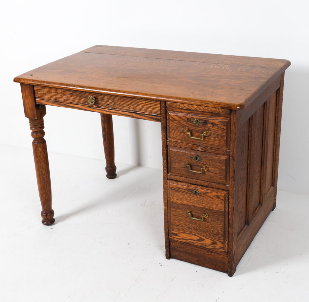 ANTIQUE OAK WRITING DESK: Brass hardware. Dimensions: H 30" x W 42" x D 27". Condition: Key not included. Stress crack to top drawer. Scattered scuffs, dings, scratches. Few gouges on top. Areas of fading and discoloration. We