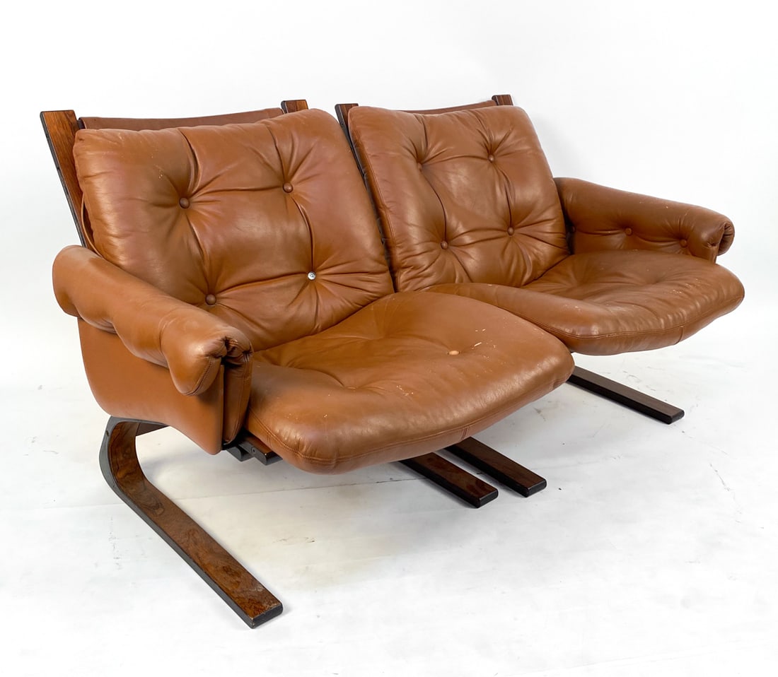 ELSA & NORDAHL SOLHEIM FOR RYKKEN KENGU LOVESEAT: Rosewood bentwood frames with tufted cognac leather upholstery. Seats can be separated. Norway, circa 1960s. Dimensions: H 29" x W 27" x D 28" x SH 18". Condition: Some wear to cushions. Wear consiste