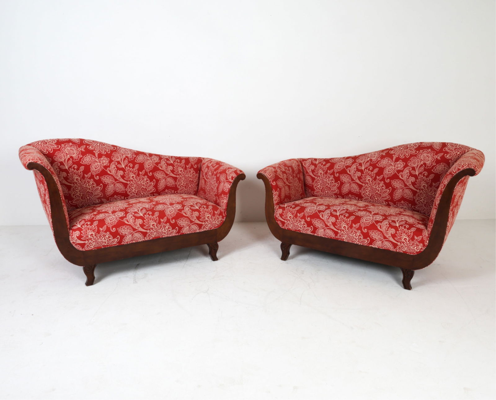 PAIR OF FRENCH EMPIRE STYLE MAHOGANY SETTEES: Carved legs. Asymmetrical form. Dimensions: (largest) H 33'x W 55.25"x D 29" seat height 16" Condition: Scuffs and dings to legs. Slight fraying to upholstery. Wear consistent with age and use.