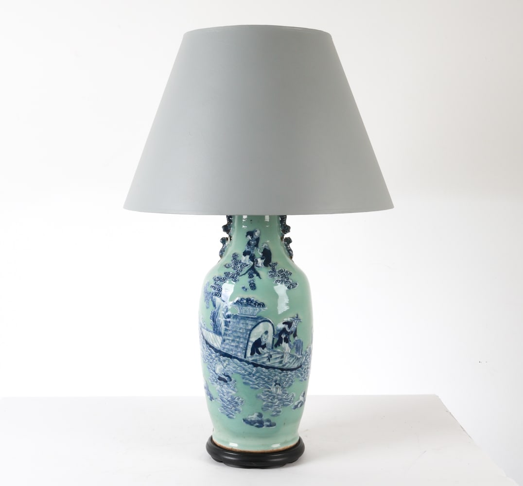 ANTIQUE CHINESE PORCELAIN VASE LAMP: With blue and white raised designs with foo dog side handles. Dimensions: H (to finial) 37" x Dia 10" (shade) H 16" x Dia 24" Condition: Slight scuff and surface soiling. Marks and creases to shade. U