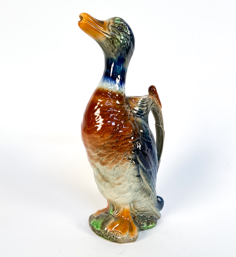ST CLEMENTS MAJOLICA DUCK PITCHER: Stamped to underside. Dimensions: H 12.5" x W 4" x D 6" Condition: Minor loss to glaze on underside. Slight crazing to glaze. Wear consistent with age and use. Presents well overall.
