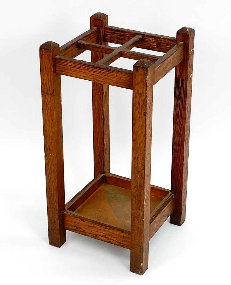 ARTS & CRAFTS MISSION OAK UMBRELLA STAND: Oak frame with copper inset in base. Unmarked. Dimensions: H 27.5" x W 13.5" x D 13.5" Condition: Some oxidation to copper. Light rubs, scratches, and marks to wood.
