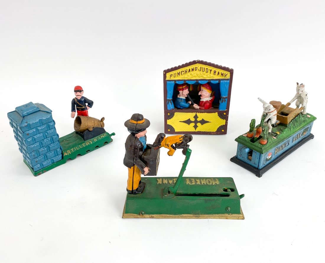 (4) REPRODUCTION CAST IRON PIGGY BANKS: Includes a Punch and Judy bank, a Monkey bank, a Bunnies bank, and Artillery bank. Dimensions: (Tallest) H 7.25" x W 6" x D 3.5" Condition: Oxidation, rubs to paint, and surface wear consistent with a
