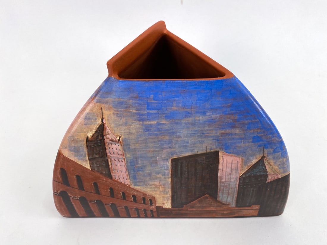 LIDYA BUZIO (1948-2014) NEW YORK CITY POTTERY VASE: Signed and dated 1981 NYC to underside. Hand painted skyline of New York City to surface of the triangular form vase. Lidya Buzio has similar works in the Brooklyn museum collection. Dimensions: H 5.7