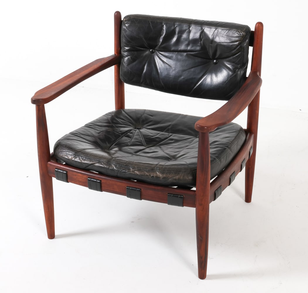 ERIC MERTHEN 'CADETT' ROSEWOOD LOUNGE CHAIR 1960S: Rosewood frame with black leather cushions. Seat is supported by a cross-hatched leather sling, while the backrest cushion is secured to the frame with leather belts. Dimensions: H 28.5" x W 27" x D 2