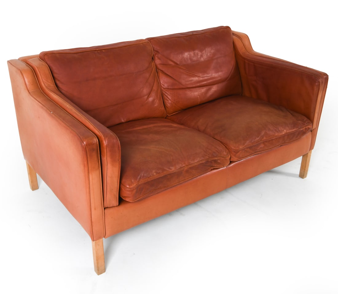 STOUBY DANISH BEECH & LEATHER SOFA: This Stouby leather sofa, marked on the underside of its cushions, features orange-tone leather upholstery and sturdy beech wood legs. Dimensions: H 28.5" x W 55" x D 32", SH 14.5" Condition: The upho