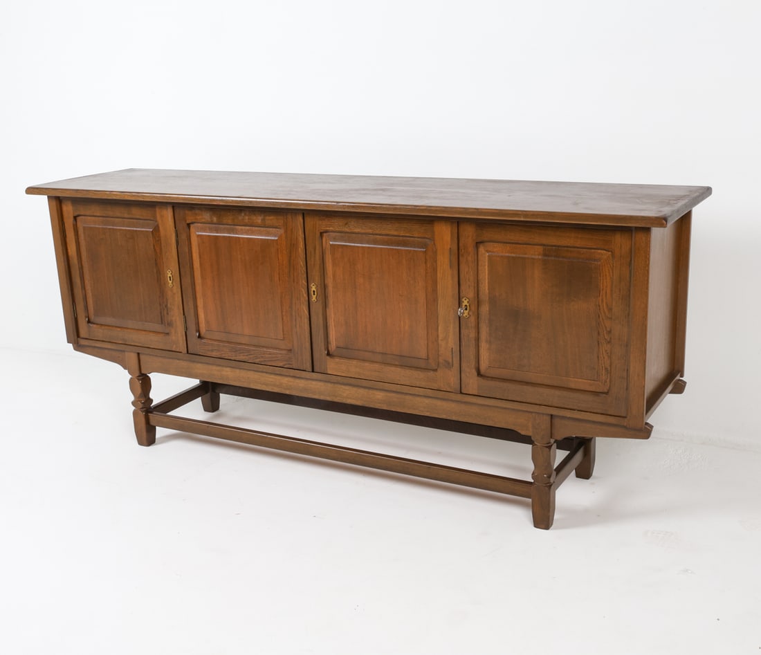 KJAERNULF STYLE DANISH OAK SIDEBOARD C. 1970S: Includes key. crafted in the style of Henning Kjaernulf. Dimensions: H 35.25" x W 82" x D 20" Condition: Surface has minor scattered scuffs and marks but presents well overall. A123