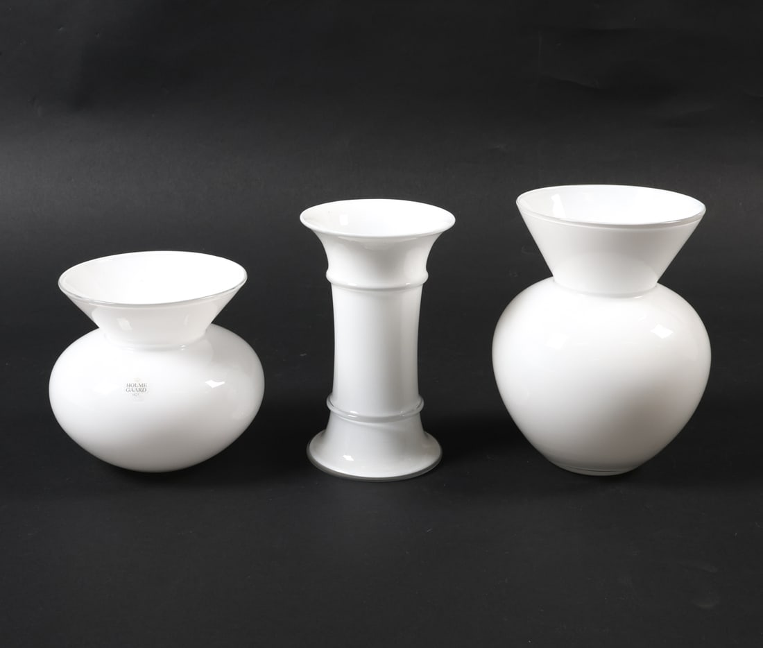 HOLMEGAARD WHITE ART GLASS VASES: (3) White glass vases in various forms. One with the Holmegaard label. Dimensions: (Largest) H 7.5" x Dia 5.25". Condition: Slight soiling to the interior of the largest vase. Vases present well overa
