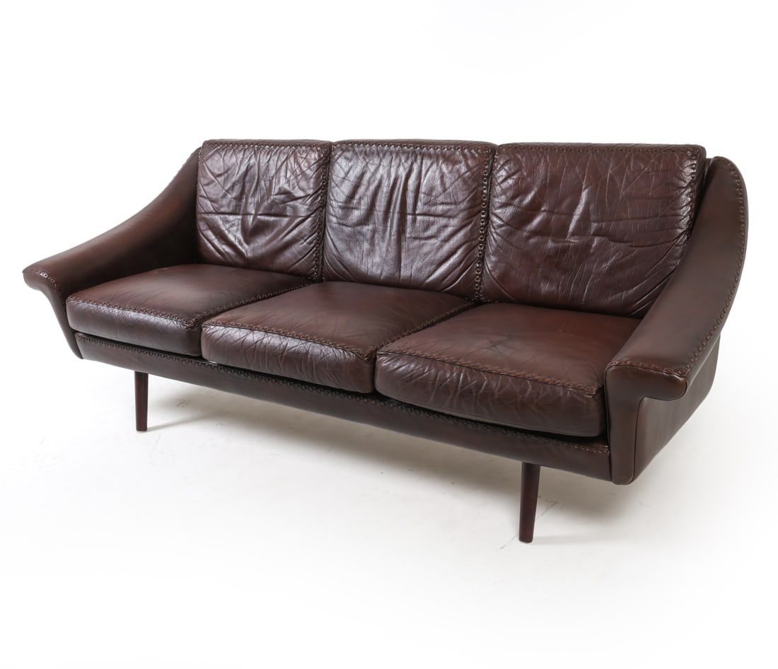 ATTR. AAGE CHRISTIANSEN DANISH LEATHER SOFA: Three-seat brown leather with accented stitching on edges and cushions. Dimensions: H 31" x W 82" x D 31", SH 17" Condition: Cushions have slight discoloration and minor indentations. Wear consistent