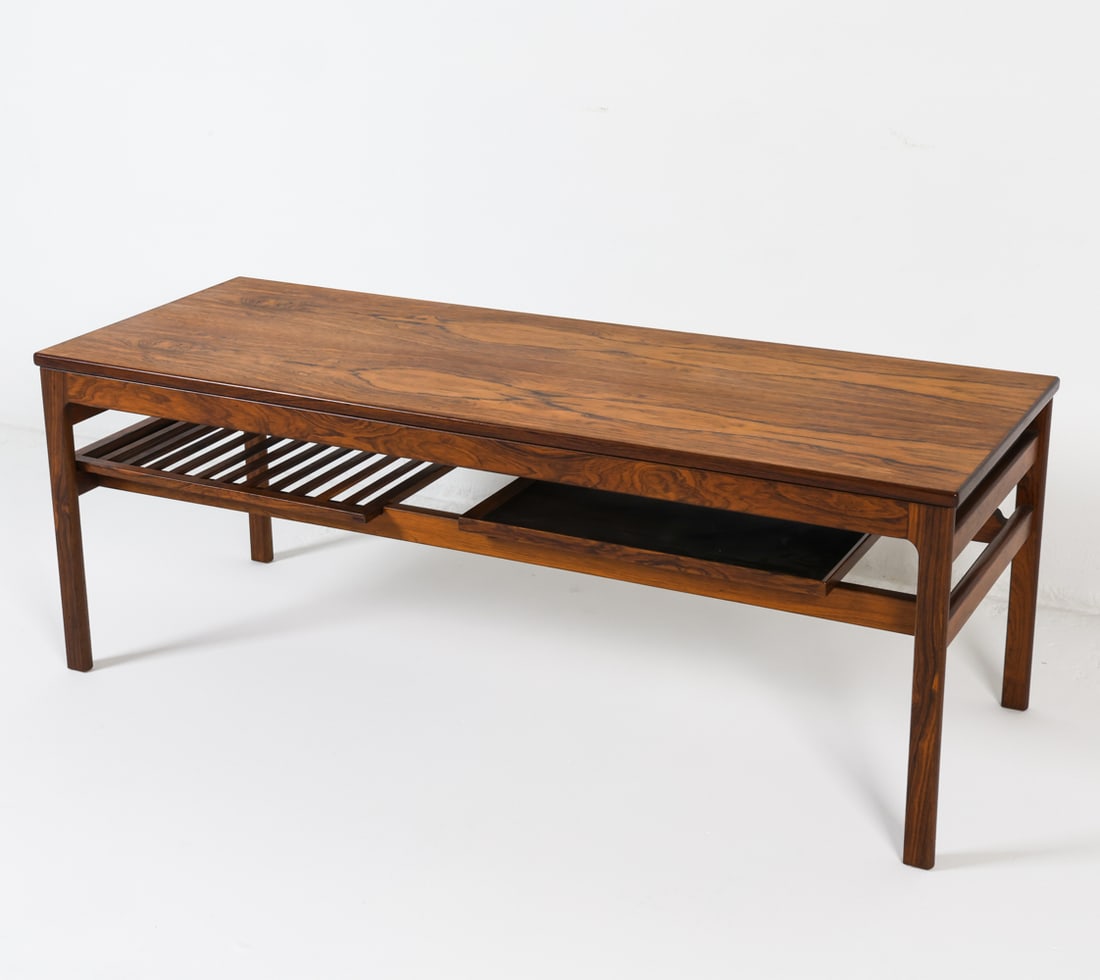 HANS OLSEN EXTENDING ROSEWOOD COFFEE TABLE: Includes (1) leaf and removable lower shelf. Dimensions: H 19" x W 53" x D 19.75" (leave) W 17" Condition: Scattered marks and scuffs. Presents well overall. GCD112