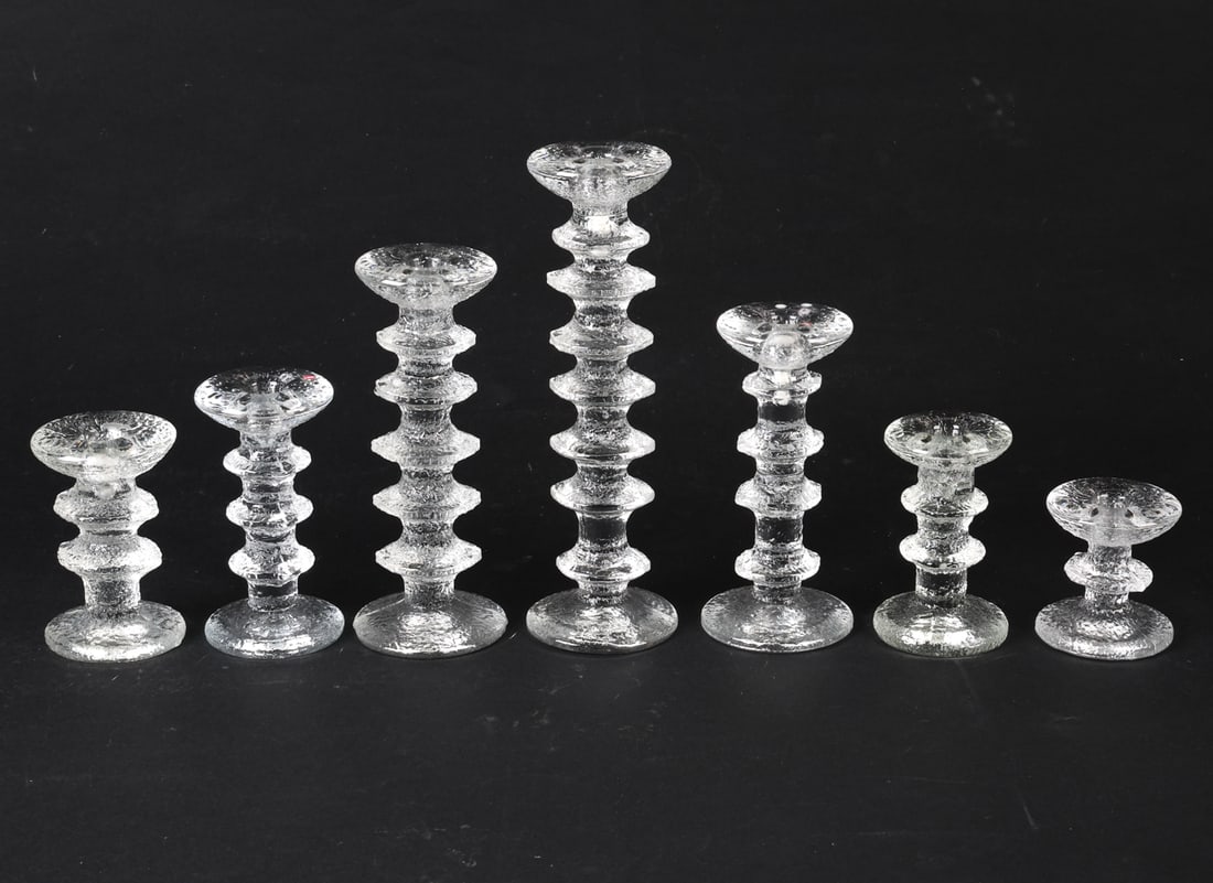 IITTALA FESTIVO GLASS CANDLESTICKS C. 1970S: Designed by Timo Sarpaneva. (7) pieces total. Few with branded sticker to tops. Finland, circa 1970s. Dimensions: Tallest H 11". Smallest H 3". Condition: Minor surface scratches, wear consistent with