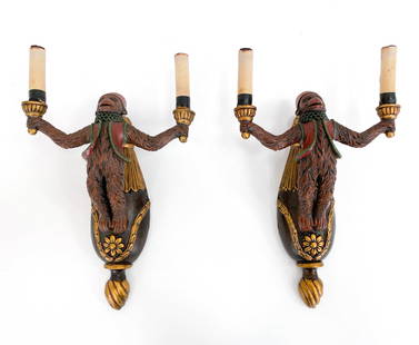 PAIR OF CONTEMPORARY MONKEY SCONCES: Pair of candelabra form 2-light monkey sconces. monkeys holding two pillar candleholders and wearing a red vest. Dimensions: H 15" x W 10" x D 5" Condition: Untested. Tape on faux candles to hold in p