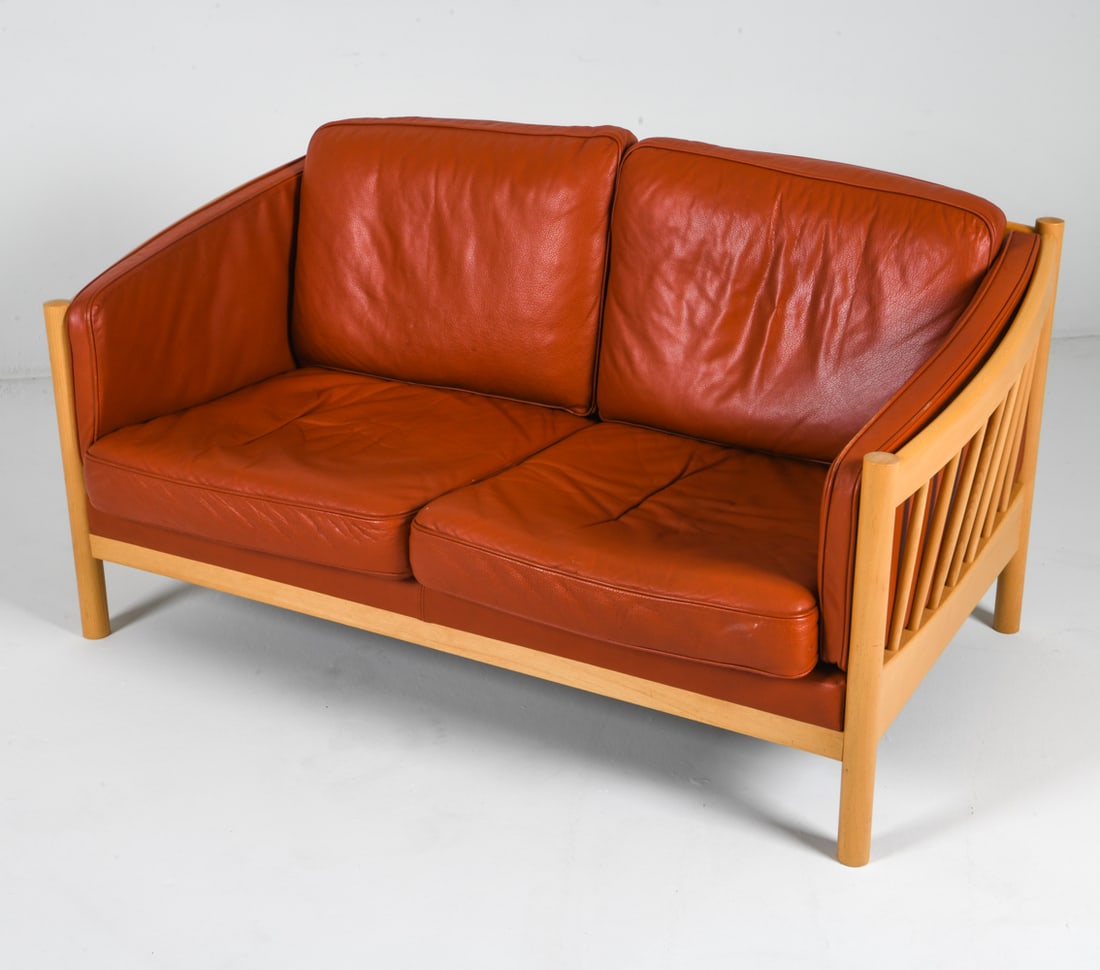 STOUBY DANISH BEECH & LEATHER LOVESEAT SOFA 1970S: (2) Seat sofa with red tan leather cushions and beech frame. Branding to fabric lining of upholstery. Dimensions: H 27.25" x W 53" x D 31" x SH 15.5". Condition: Few minor scuffs to frame. Some rubs t