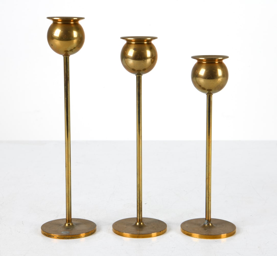 PIERRE FORSSELL BRASS 'TULIP' CANDLESTICKS: (3) Total. For Skultuna. Polished brass. Marked under bases with artist's signature. Circa 1970s. Dimensions: Tallest H 9". Condition: Some areas of oxidation and tarnish to finish. Wear consistent wi