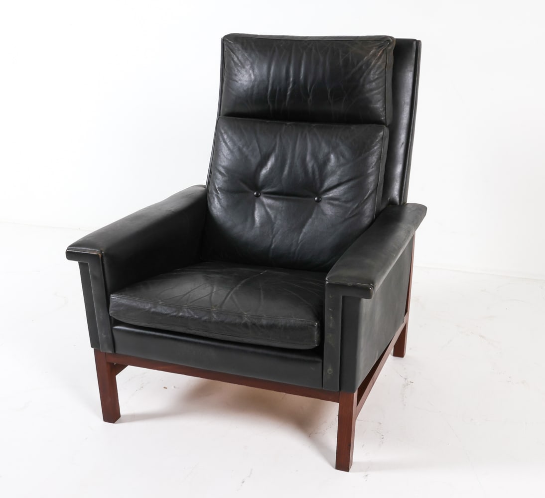 HANS OLSEN STYLE LEATHER HIGH BACK LOUNGE CHAIR: Black leather with teak frame. Denmark. Circa 1960s. Dimensions: H 39.5" x W 30.5" x D 29.5", SH 15.5" Condition: Moderate creases and marks to seat cushion. Scuffs to seat back edges. Moderate tobacc