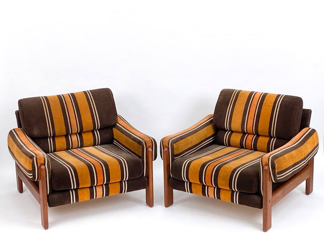 PAIR OF MID-CENTURY TEAK LOUNGE CHAIRS, C. 1970S: Orange, yellow, and brown striped upholstery, with teak frame. Apparently unmarked. Dimensions: H 28" x W 36" x D 34" x SH 15" Condition: Few light surface marks. PM12