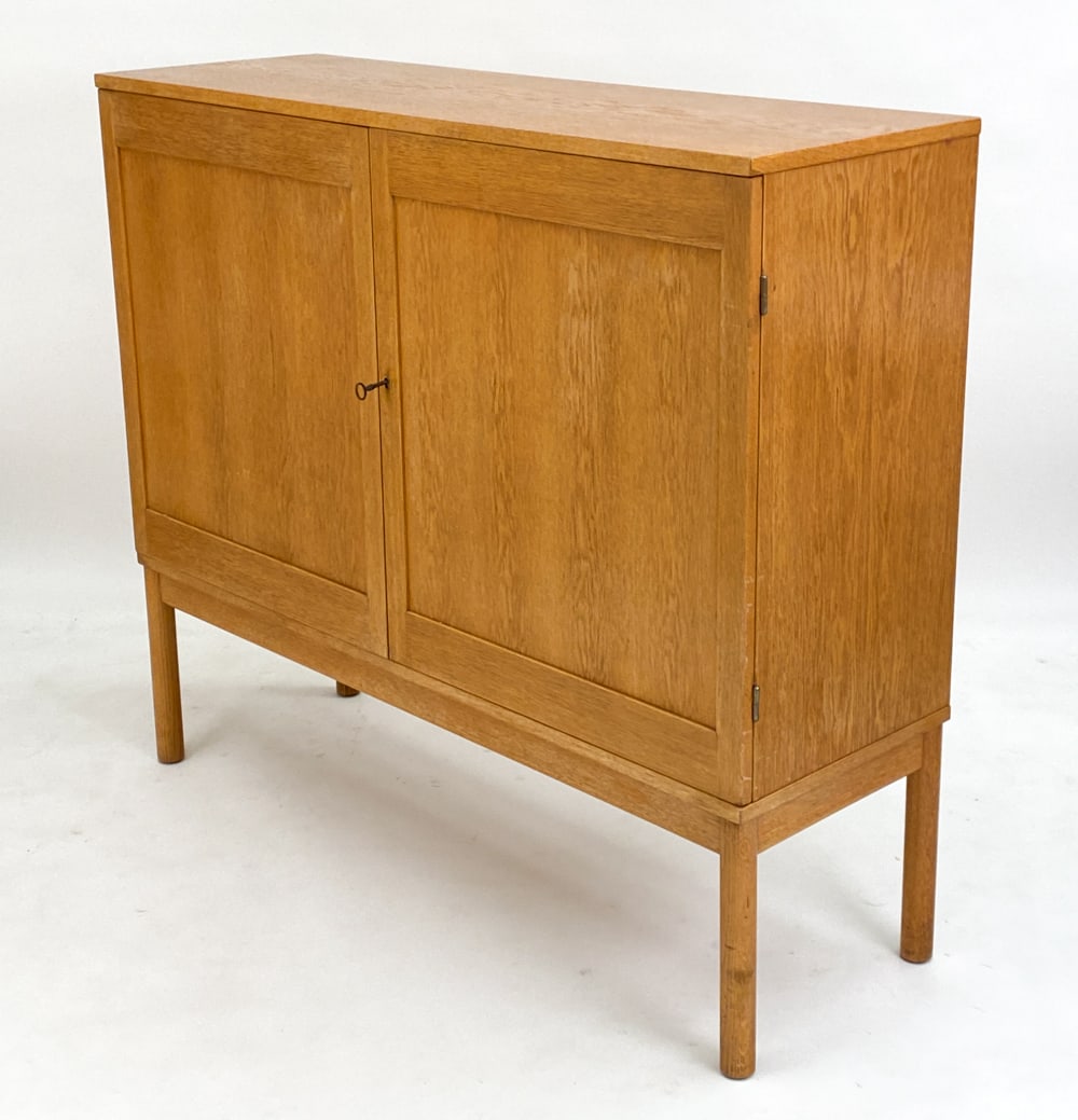 MID-CENTURY SWEDISH OAK HIGHBOARD: 2-door highboard with adjustable shelves and drawers to interior. Apparently unmarked. Circa 1960s. Includes a key. Dimensions: H 48" x W 55" x D 17.5" Condition: Light surface wear consistent with ag