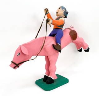 DELBERT BUCK RIDING PIG FOLK ART SCULPTURE: Folk art sculpture of a woman riding a pig with its legs in the air. Signed on underside and dated 94'. Dimensions: H 25" x W 30" x D 7.5" Condition: Losses, cracks, and chips to paint.