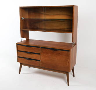 SCANDINAVIAN WALNUT BOOKCASE CABINET C. 1960S: Key included. Two-part cabinet bookcase with glass sliding doors, adjustable shelves, and ebonized drawer pulls. Dimensions: H 63.5" x W 51.5" x D 19.75". Condition: Few water rings. Minor dings, scuf